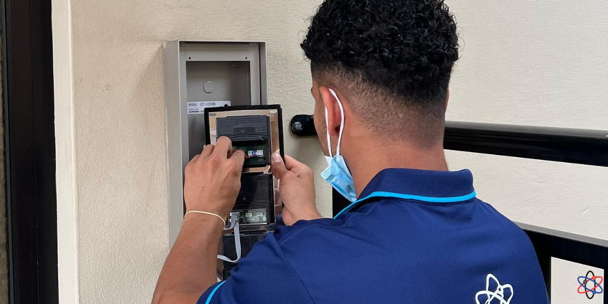 A man in a blue shirt is using a phone to make a call, focused and engaged in conversation.