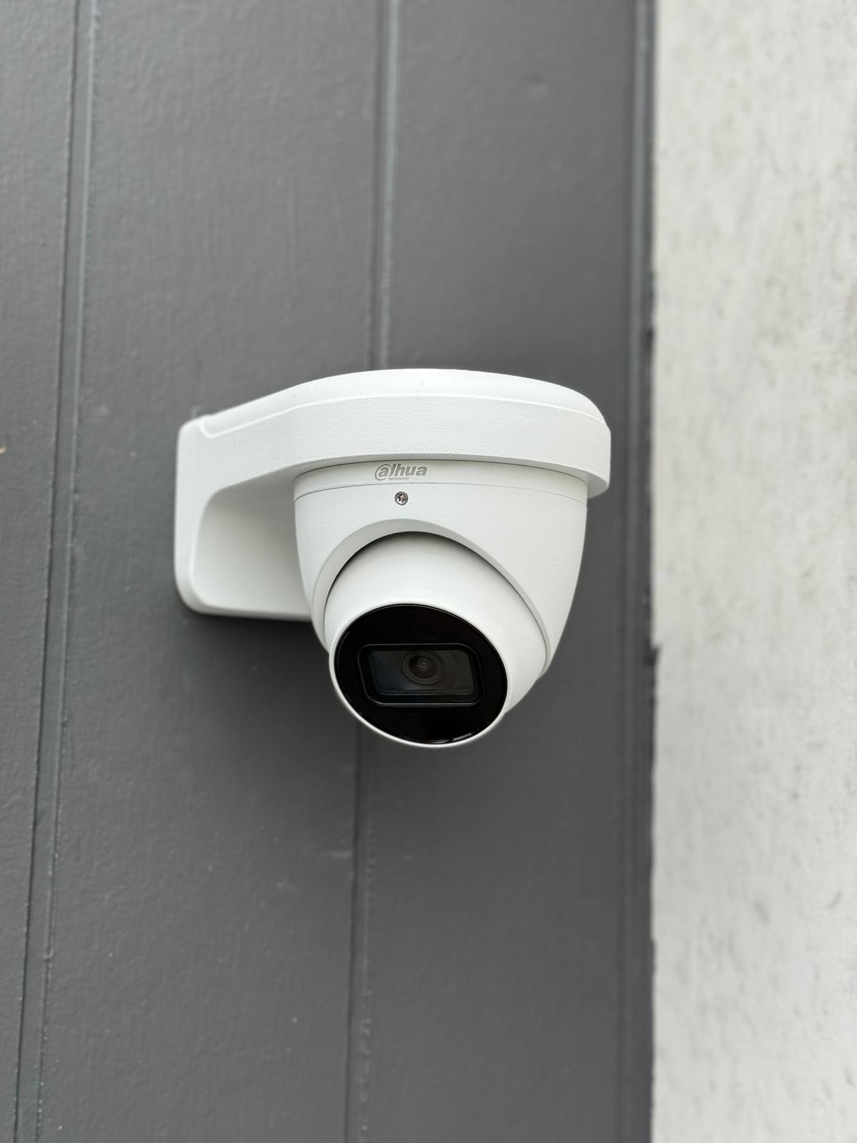 A security camera mounted on a wall, symbolizing data protection and surveillance for secure business environments.