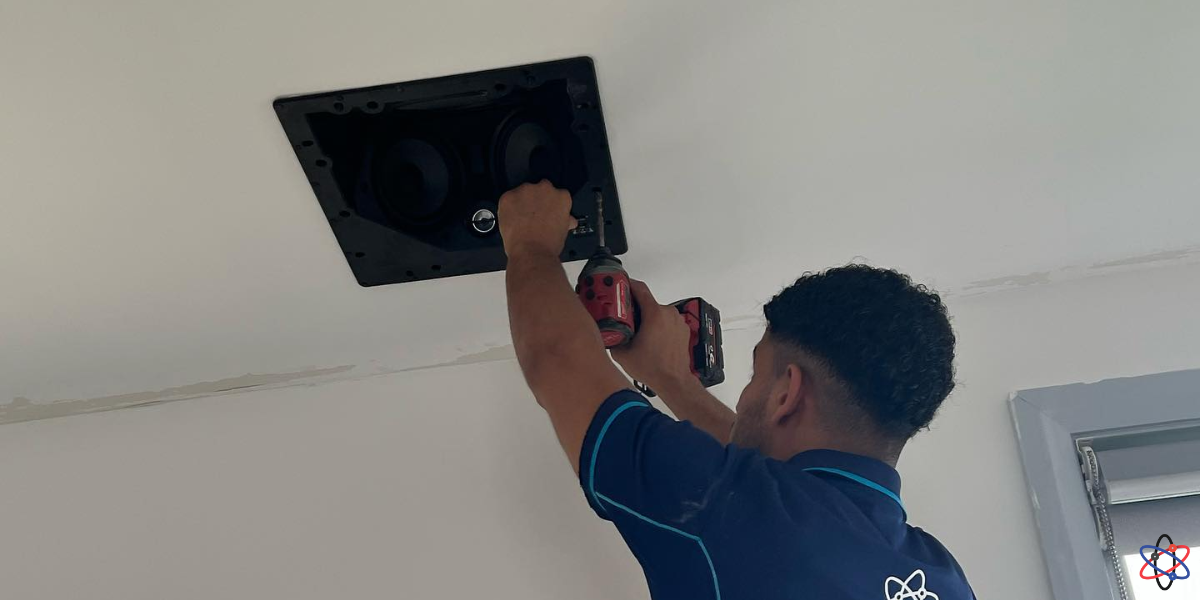 A man repairs a ceiling fan using a screwdriver, demonstrating home maintenance skills and attention to detail.